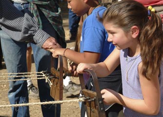 girl learning to make rope at Marshall Park, Coloma